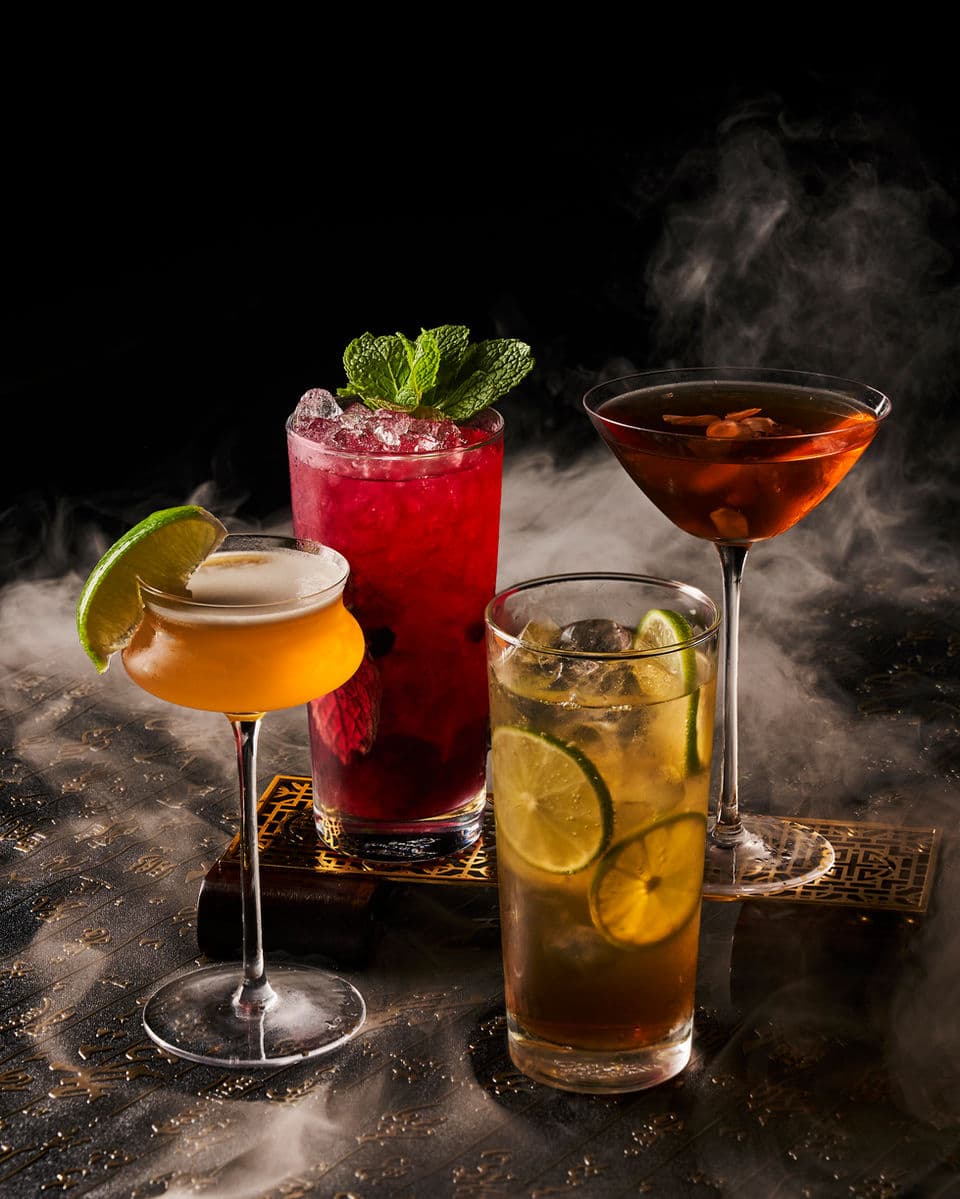 A group of colorful Synthesis cocktails served with smoke